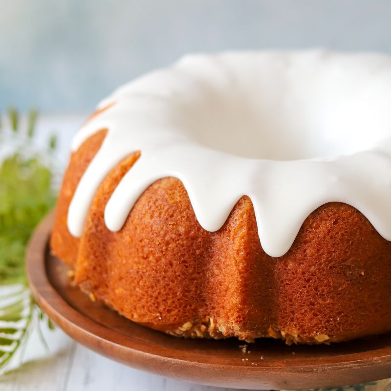 almond butter coffee cake with white vanilla glaze dripping down the sides