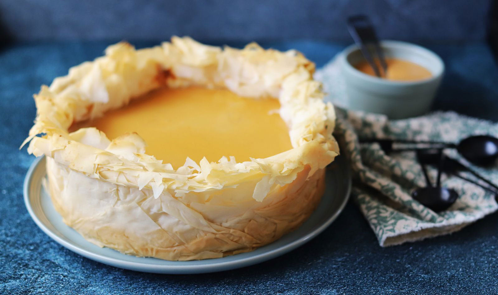 A dramatic flakey Phyllo crust around a rich cheesecake with an amber honey color.
