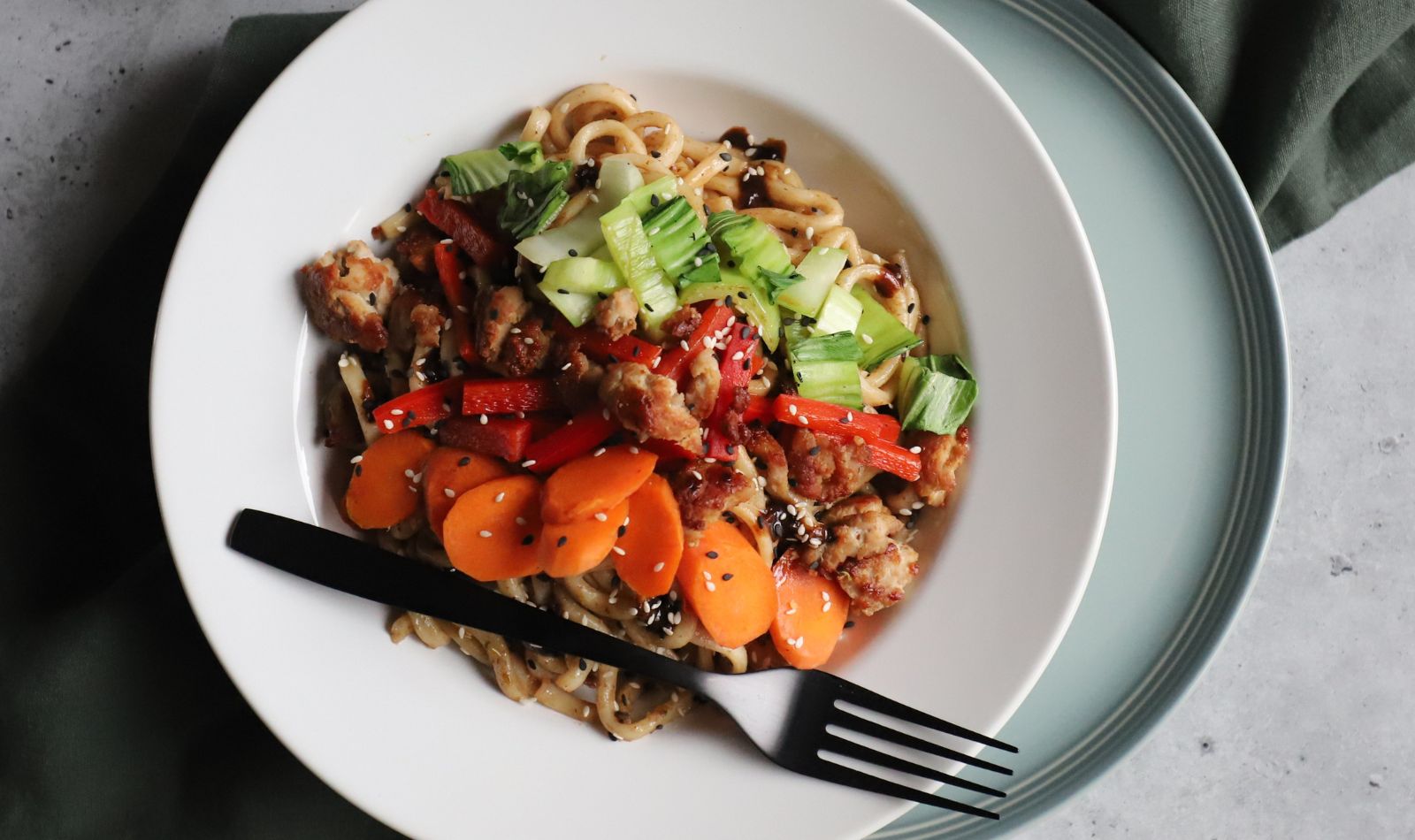 Pork Udon Noodles with Peanut Sauce topped with stir fried and fresh vegetables