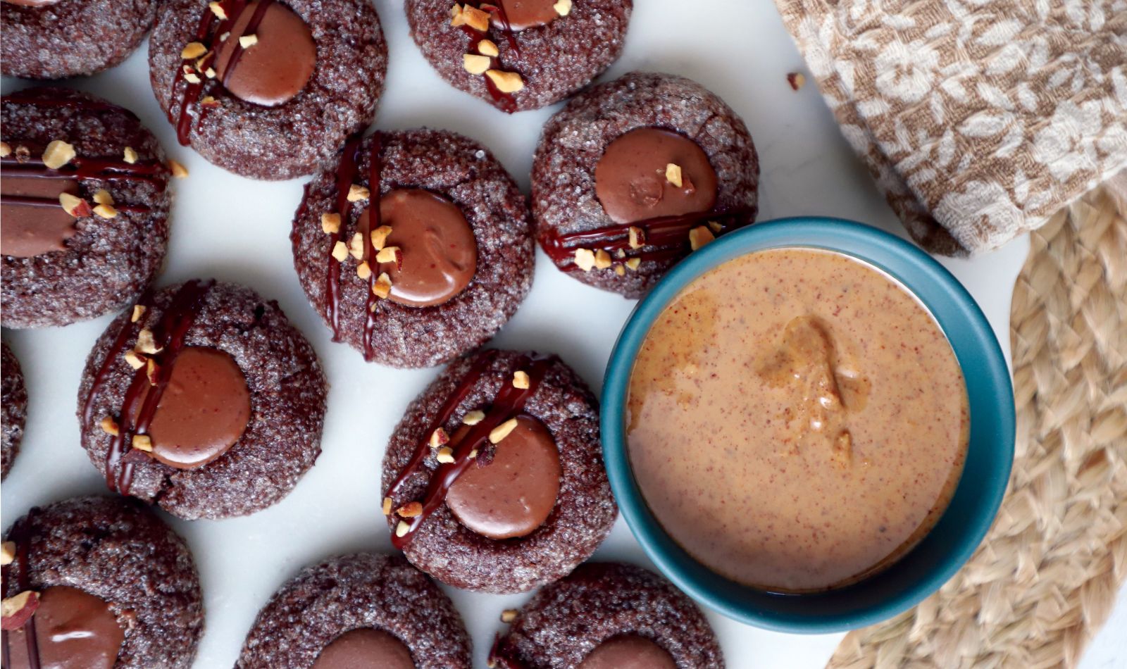 Chocolate almond thumbprint cookies with milk chocolate ganache, topped with diced almonds and dark chocolate stripes recipe